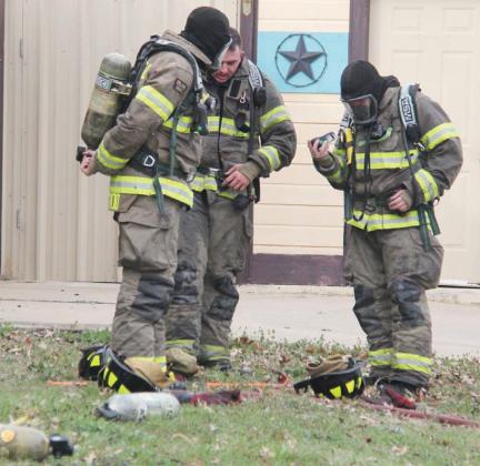 Firefighters check their air tanks after responding to a house fire on Mesquite Street. Paul Gaudette | Citizen staff photo