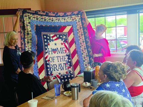 A handmade quilt is showcased by Quilters Judy Angle and Peggy DeLaVergne. Veteran Ray LaBaume received the quilt from the Quilt of Valor Foundation in honor of his service. Wyndi Veigel-Gaudette | Citizen staff photo