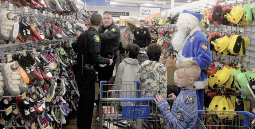 Dublin Police Chief Cameron Ray helps other law enforcement officers choose shoes for kids they are helping shop with at the 5th annual Erath County Shop with a Cop, Thursday, Dec. 19. The annual event provides Erath County kids $250 to shop with at the Stephenville Walmart and they are paired with area law enforcement personnel. For more photos see the Dublin Citizen Facebook page. Paul Gaudette | Citizen staff photo