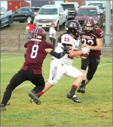 Lingleville Cardinal Austin Kelley (above) leaps to receive during the home game against Three Way on Friday, Sept. 15 which resulted in a 54-7 win for the Cards. This win moved the Cardinals to 2-2 for the season. At left, Wyatt Ray and Jaxson Bays move in to tackle a Three Way ball carrier. Paul Gaudette | Citizen staff photos