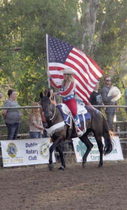 Leah, a rodeo rider, carries the American flag into the arena for the National Anthem at the beginning of the Dublin Rodeo Saturday, Aug. 17. Wyndi Veigel-Gaudette | Citizen staff photo