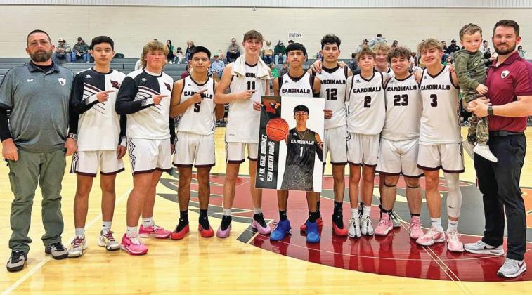 Lingleville Cardinals coaches and players join senior Issac Martinez (center, with poster) in congratulations as he eclipsed 1500 career points during the Feb. 10 preview playoff game against Ballinger at home. Paul Gaudette | Citizen staff photo