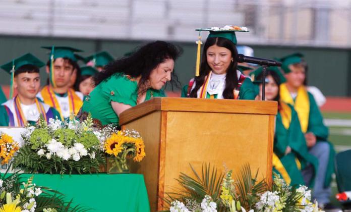 DHS principal Norma Villicana-Arreguin sets up the podium for valedictorian Wendy Calderon