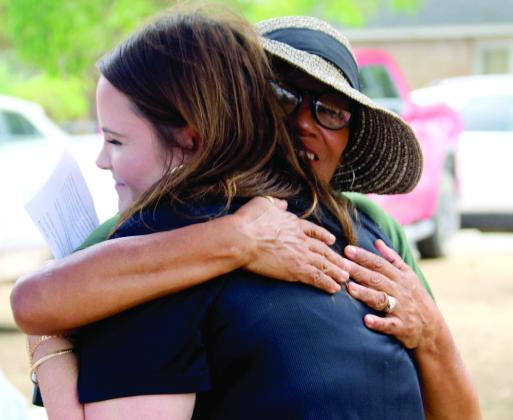 Above, participants in an outreach event at Kingdom Threads, hosted by Texas Bank, receive all kinds of free goodies. Left, Texas Bank Dublin Branch Manager Amanda Pursley exchanges a hug with Kingdom Threads Manager Velvet Earles. Velvet is known for giving great hugs and prayers. To help with their wishlist, scan the QR code below. Paul Gaudette | Citizen staff photos