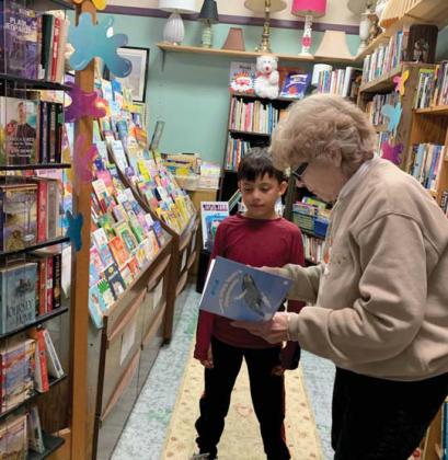 Gwen Osman shows a young reader a book at CWJC in downtown Dublin. As a volunteer she has helped the store organize the book section in order to make it more appealing to shoppers and encourage literacy. Submitted photo