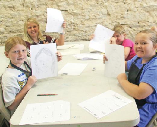 Participants show off their portraits at the annual Art Camp. Wyndi Veigel-Gaudette | Citizen staff photo