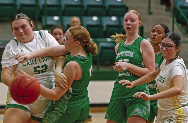 Dublin Lady Lion Adriana Stewart (above) snaps to guard a Bangs Lady Dragon advancing the ball during a Saturday, Nov. 15 home game that ended in a win for Dublin. At left, Bayli Jackson and Savannah Chacon fight Bangs opposition under the net for control of the ball. Danielle Meador | Citizen staff photos