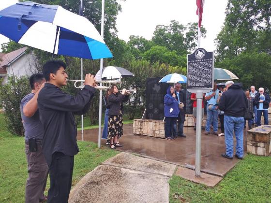 Local students play Taps to a reverent crowd during last year's Memorial Day service at the Dublin Public Library Veterans' Memorial.