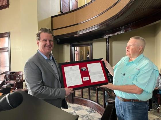 County Judge Brandon Huckabee was presented with a framed copy of his very first agenda as newly elected county judge by citizen Vince Parro.