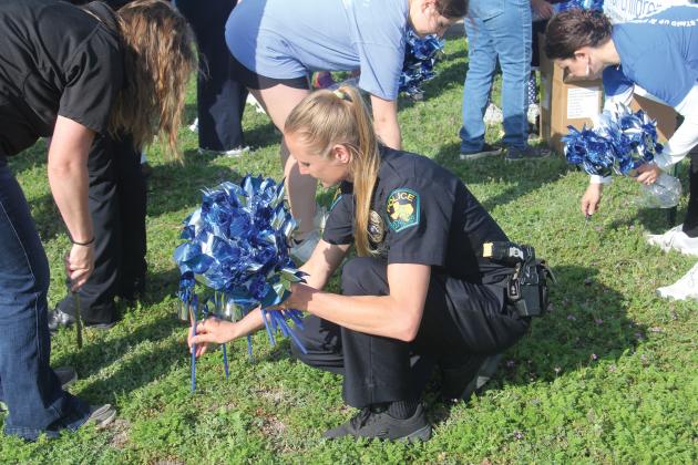 Dublin School Resource Officer Brandi Hoffman placed a blue pinwheel in the ground in honor of April’s Child Abuse Prevention Month at the Paluxy River Children’s Advocacy Center in Stephenville. 504 pinwheels were placed outside the center in honor of the 504 cases of suspected child abuse or neglect that occurred in Erath County in 2022.