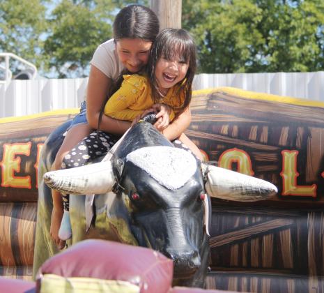 Young girls enjoy riding a mechanical bull at the annual Hispanic Heritage Festival Sept. 30, 2023, hosted by the Dublin Chamber of Commerce. The event showcased a day of fun including boxing, more than 60 vendors, tasty food, games, a rodeo with escaramuza and a cabalgata (trail ride).