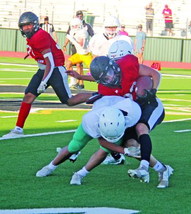Dublin Lions rush a Hamilton Bulldog ballhandler from the front and back to take him down in the scrimmage in August 2023 at Dublin High School’s Bob and Norma Cervetto Field.