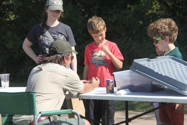 A park ranger with Texas Parks &amp; Wildlife educates young boys on nonvenomous snakes in Texas. Kids and adults alike were able to give gentle pets to the snakes.