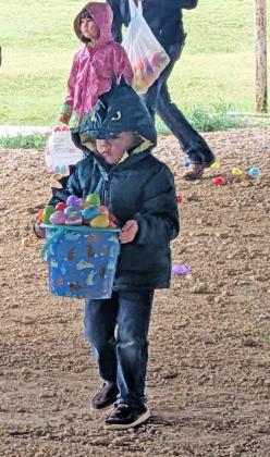 A little boy balancing a basket of eggs.