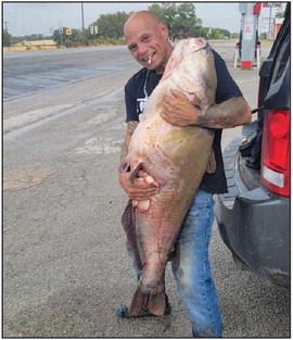 Kevin Kirkham recently caught an 84 pound catfish at Lake Proctor. Kirkham caught the giant fish with rod and reel on a 12 pound line and had to go swimming to get the fish back to the shore. Kirkham said he had been catching about 30 pound fish each night. Wyndi Veigel | Citizen staff photo