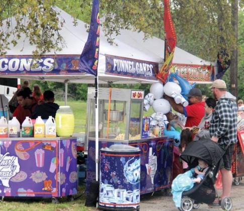 Shoppers visit snocone and funnel cake vendors during the Solar Shamrock Festival hosted by the Dublin Chamber of Commerce. Below, kids enjoy playing with bubbles in the park. Paul Gaudette | Citizen staff photo