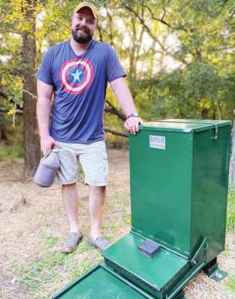 Dr. Brad Fails loads a specialized hog feeder with HogStop during the testing phase
