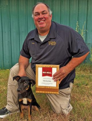 Animal Control/Code Enforcement Officer Larry Stanford and Peanut display a new plaque awarded to the city for its No Kill Animal Shelter status. Peanut is up for adoption. Courtesy photo