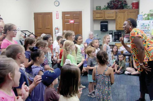 Kids enjoy dancing to songs performed by Kenya native Elizabeth Kahura in a ‘Folktales from Africa’ program as part of Dublin Public Library’s Summer Reading Club. Below left, kids listen to a story performed with puppets about the importance of being nice. Below right, kids group under a safari canopy pointing out some animals learned in Swahili like simba (lion), twiga (giraffe) and tembo (elephant). Wyndi Veigel-Gaudette | Citizen staff photo