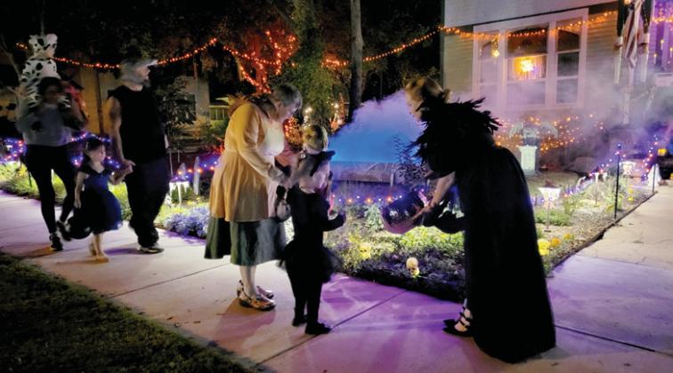 Georgia Gasparek hands out candy on Patrick Street to eager trick-ortreaters. The fully decked out home drew many kids and adults for Halloween. Wyndi Veigel-Gaudette | Citizen staff photo Citizen staff photo