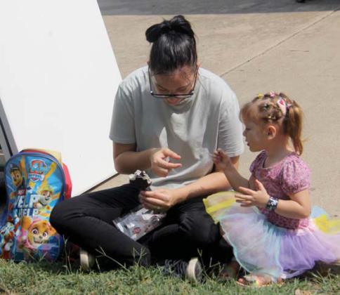 A mom picks off pieces of chocolate from a Dairy Queen Dilly Bar to give to her daughter at the Back to School Fair at the Dublin Public Library Saturday, July 27. Paul Gaudette | Citizen staff photo