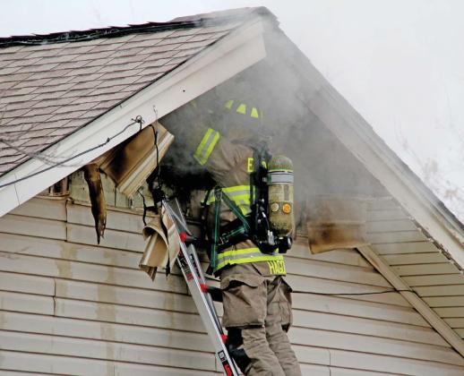 Dublin Volunteer Firefighter Zach Hagood works to help extinguish a house fire on Mesquite Street Thursday, Feb. 15. The home is a total loss. Wyndi Veigel-Gaudette | Citizen staff photo