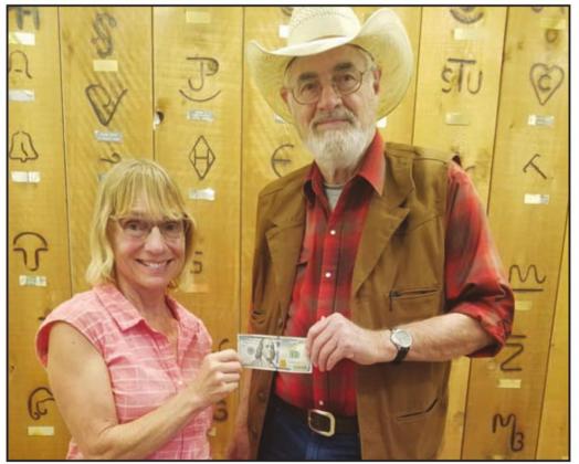 Gene Pearcey (seen below as Evil Roy in his role as a sharp shooter) won the $100 drawing from the Aug. 14 Secrets of the Rodeo Heritage Museum event. He was presented with the bill by Peggy Tolboom, owner of Dairy Solutions, who sponsored the event. | submitted photos