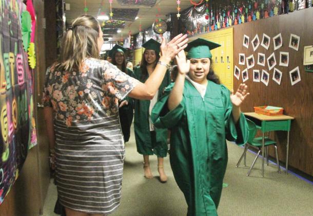 Dublin Senior class members show off their caps and gowns on all DISD campuses Monday, May 8 in a senior walk. Above, seniors exchange high fives with Dublin Elementary School Principal Kalley Mitchell. Wyndi Veigel | Citizen staff photo