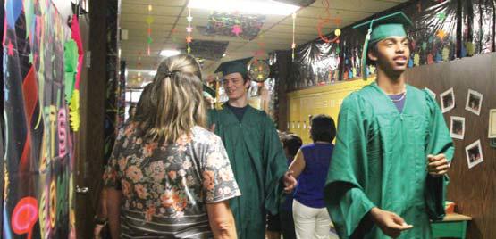 Senior Dalan Rasberry walks through the halls at the elementary school showing off his cap and gown to students. Wyndi Veigel | Citizen staff photo