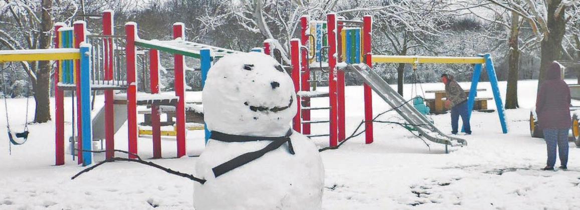 A family plays behind a snowman at Dublin City Park Friday (above) while Corner Lot decorations sat covered in snow from New Year’s Eve snowfall. Paul Gaudette | Citizen staff photo