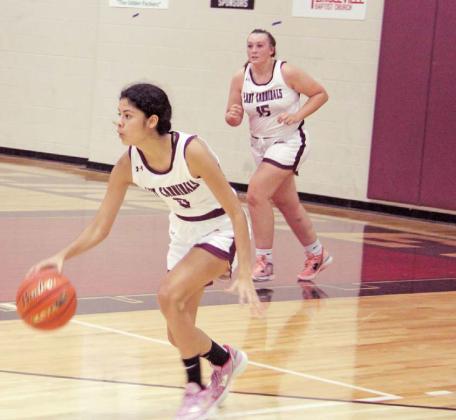 Lingleville Lady Cardinal Araceli Rangel moves the ball up the court while Katelyn Brooks rushes to offer assistance during a home game against Merkel JV on Nov. 22. The game was evenly matched at 10-10 in the first quarter, but Merkel gained ground in the second and took a 36-28 win in the end. Paul Gaudette | Citizen staff photo