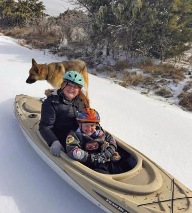 Kate and Colton Haley enjoy a snow day inside a kayak with their furry companion. Lisa Haley Courtesy photo