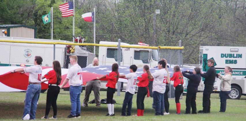 Everyone’s eyes were drawn to centerfield where older players and first responders carried in a large flag provided by Crazy Heart Sound &amp; Lighting for the National Anthem at DBSA’s Opening Day festivities Saturday. Vendors and guests were also at the park for the Solar Shamrock Festival hosted by the Dublin Chamber of Commerce. For photos, see page A8. Paul Gaudette | Citizen staff photo
