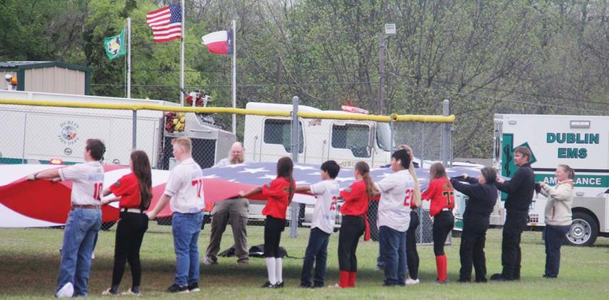 Everyone’s eyes were drawn to centerfield where older players and first responders carried in a large flag provided by Crazy Heart Sound &amp;amp; Lighting for the National Anthem at DBSA’s Opening Day festivities Saturday. Vendors and guests were also at the park for the Solar Shamrock Festival hosted by the Dublin Chamber of Commerce. For photos, see page A8. Paul Gaudette | Citizen staff photo