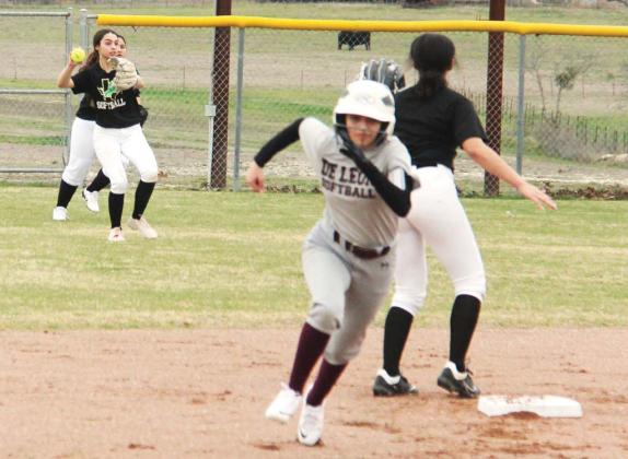 Dublin Lady Lion (above, outfield) recovers a ball in a bid to stop DeLeon runners during the home scrimmage Feb. 9. Teammate Cassidy Adair (left) kicks up dirt as she slides into second base. Paul Gaudette | Citizen staff photo