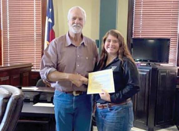 Deputy Vanessa Griffin receives a 10-year service award from the county presented by Commissioner Ray. Submitted photo