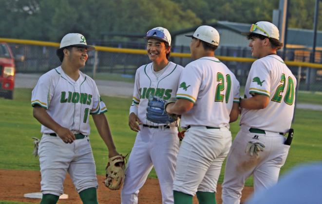 Dublin Lions join Joe Salinas on the pitcher’s mound Thursday, April 2 for a friendly chat before they took on Eastland at home. Below, Ivan Phelps blasts past first base before the Maverick can tag him out. Paul Gaudette | Citizen staff photo