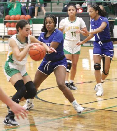Lady Lion Olivia Salyer edges past Peaster Greyhound defense while teammate Adriana Rosalez tries to break free of a defender to help. Paul Gaudette | Citizen staff photo