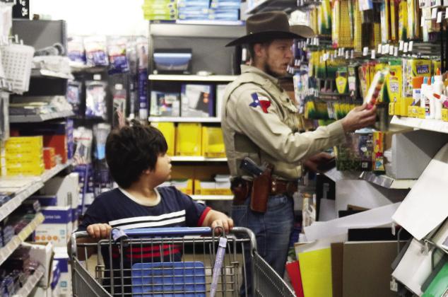 Above, a game warden helps a young boy pick out a pair of binoculars. Below, Constable Ryan Gibson aids a child in picking out art supplies. Wyndi Veigel-Gaudette | Citizen staff photos