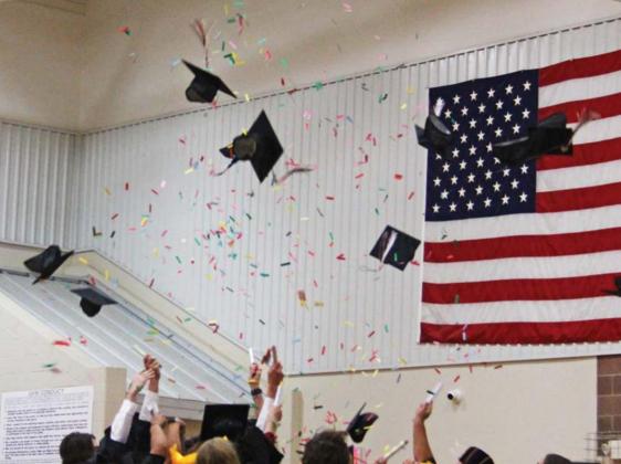 Lingleville High School graduates have a colorful cap toss as they throw confetti along with their hats at the end of Friday’s graduation ceremonies. Ivy Aikman (below) presnts a rose and embraces someone special as the seniors honored those who helped them along the way. Paul Gaudette | Citizen staff photo