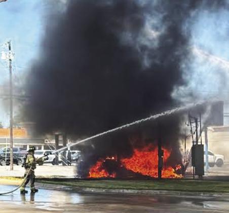 A fire started by a two vehicle accident on Washington Street in Stephenville blocked the roadway for more than an hour on Wednesday, Sept. 3. No one was injured. Below, Stephenville firefighter Zach Hagood sprays water on Baxter Chemicals to keep the building safe during the vehicle fire. Wyndi Veigel-Gaudette | Citizen staff photo