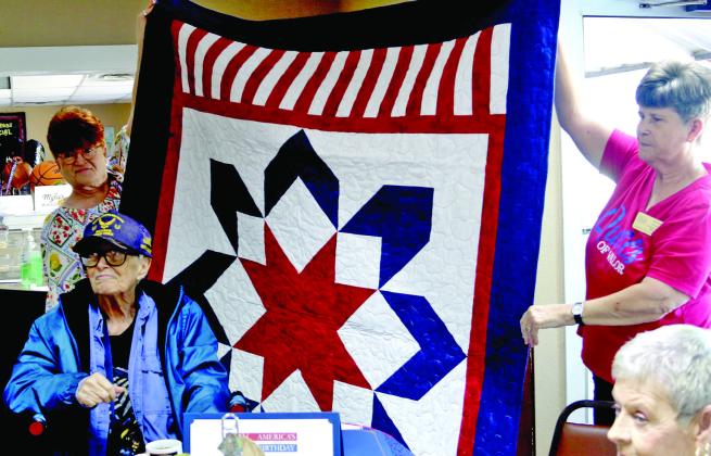 Air Force Veteran Sandra Cullipher smiles as she receives a beautiful handmade patriotic quilt from the Quilts of Valor Foundation. Wyndi Veigel-Gaudette | Citizen staff photo