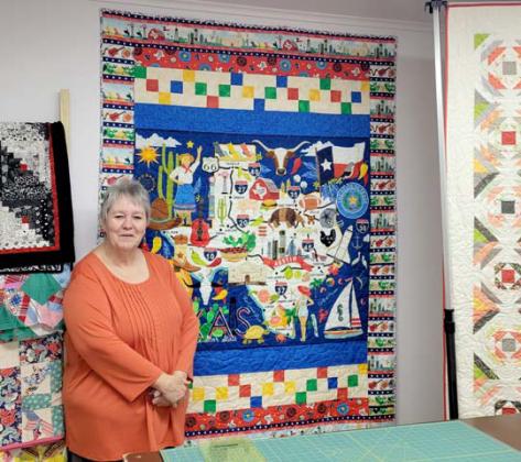 Trudy Spears, owner of Stitching Sisters Quilt Shop in Comanche (formerly Austin Street Fabrics in Dublin) stands with a colorful quilt designed for the All Texas Shop Hop, which will continue through the end of April. Wyndi Veigel-Gaudette | Citizen staff photo