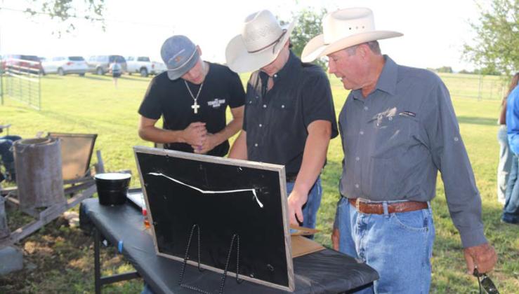 Dr. Dennis Reed looks at newspaper clippings and a scrapbook full of well-wishes at a party celebrating him being a vet for 50 years. Below, more than 120 people enjoy a celebration at the Fritts farm with a fajita dinner and cupcakes. Wyndi Veigel-Gaudette | Citizen staff photo