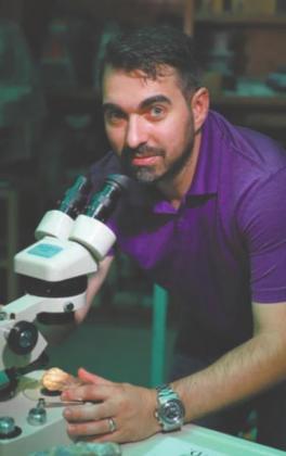 Ryan Morgan examining the fossil of a newlydiscovered plant species