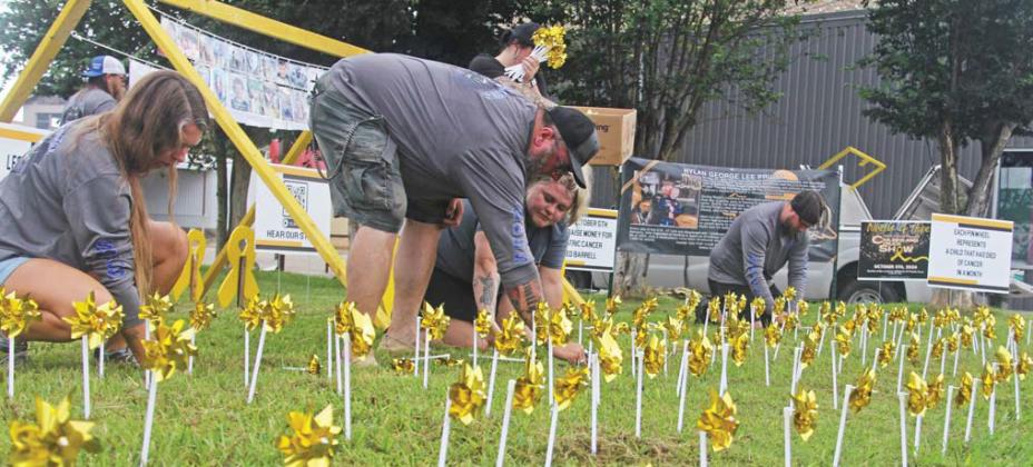 Organizers with the Rylan Strong Network place gold pinwheels in the Corner Lot in honor of Childhood PageA8 CancerAwarenessMonthinSeptember.ThereisafundraiserforthenonprofitatthelibrarythisSaturday. Paul Gaudette | Citizen staff photo