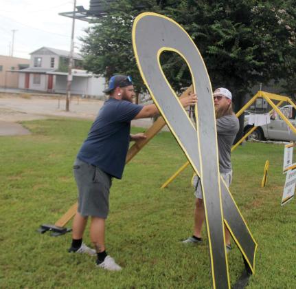 Volunteers with the Rylan Strong Network place signs and gold ribbons at the Corner Lot in honor of Childhood Cancer Awareness month. For more photos of the event, see the Dublin Citizen Facebook page. Paul Gaudette | Citizen staff photo