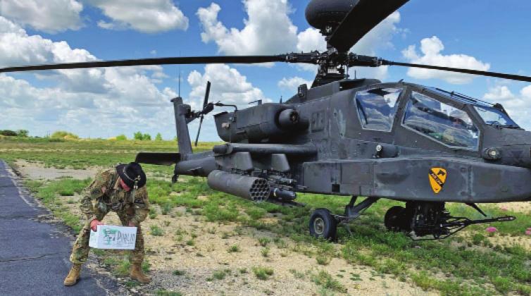 US Army Major Justin Huckabee loads a box of Dublin Bottling Works sodas onto an Apache helicopter he flew in to Dublin Airport as part of his official final flight on July 7. The sodas were handed out at the hangar at Fort Hood when he returned (below, left) and met up with his wife, Ashley, and children, Josh and Jaci. Brad Stanford and Ashley Huckabee | submitted photos