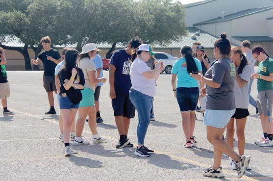 Band Director Cathryn Smith shows band students the correct placement of where they should be standing through an app. Below, students move into the correct place in their upcoming marching routine. Wyndi Veigel-Gaudette | Citizen staff photos