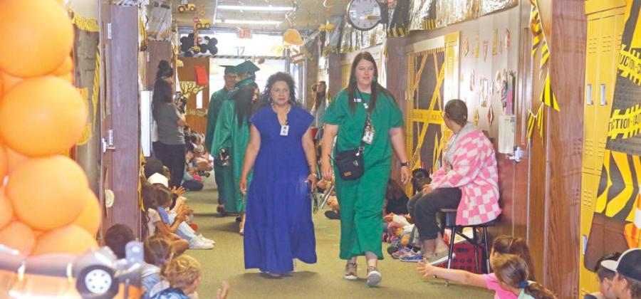 Seniors and kindergartners alike showed off their Dublin green caps and gowns at the annual Senior Walk Tuesday, May 13. The DHS grads will participate in commencement ceremonies Friday, May 23 starting at 7 p.m. at Cervetto Field. Below, DHS Principal Dr. Norma Villicana-Arreguin and Dublin Elementary School Vice Principal Ryan Lewis lead the graduates through the elementary school halls. For more photos see The Dublin Citizen Facebook page. Wyndi Veigel-Gaudette | Citizen staff photos